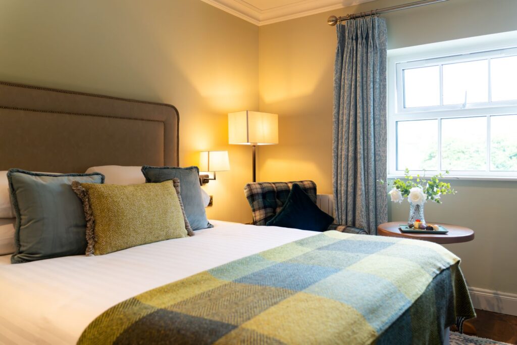 A bed with pillows and a lamp in a room.