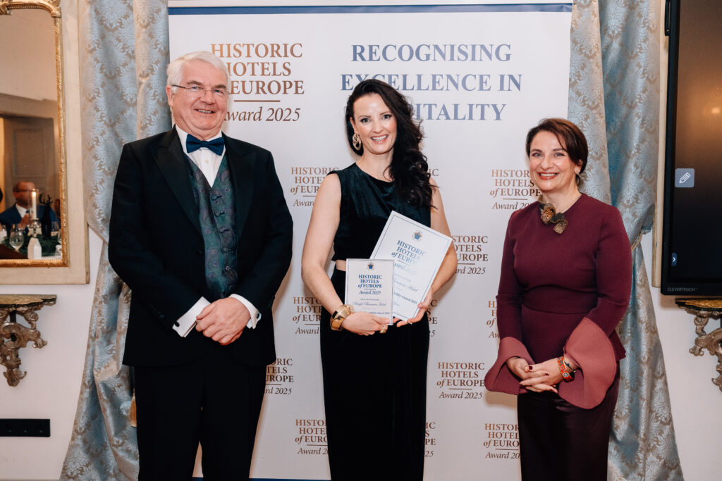 IMF_0440 Three people stand in front of a banner that reads