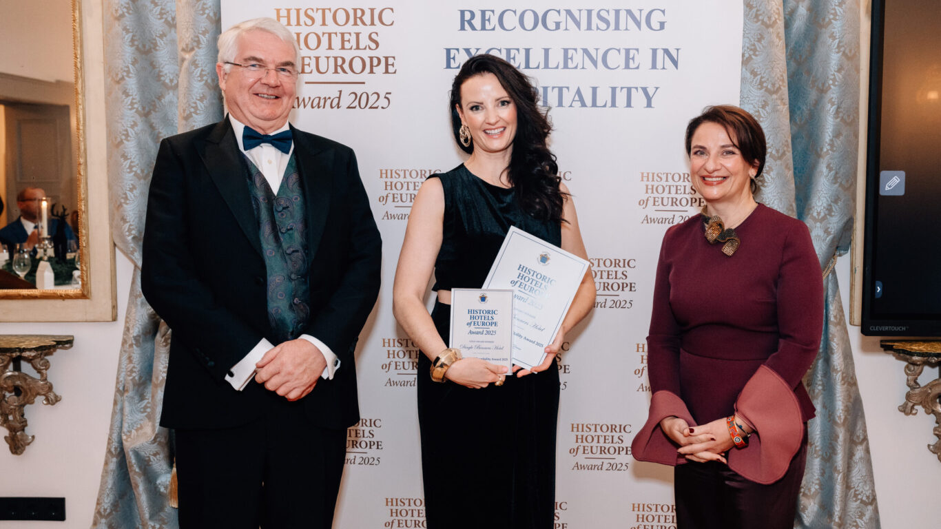 Three people stand in front of a banner that reads