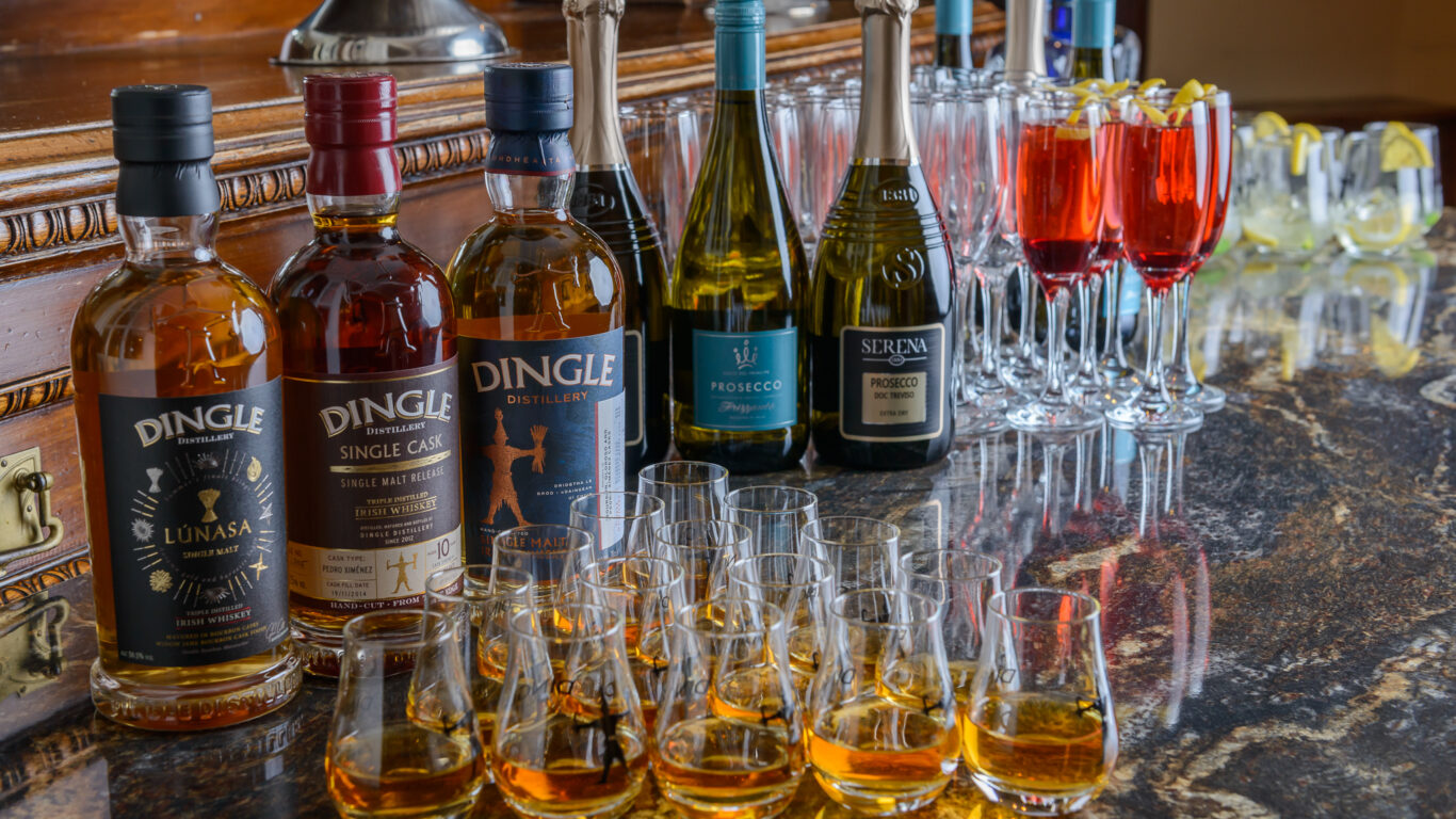 A group of bottles and glasses on a table.