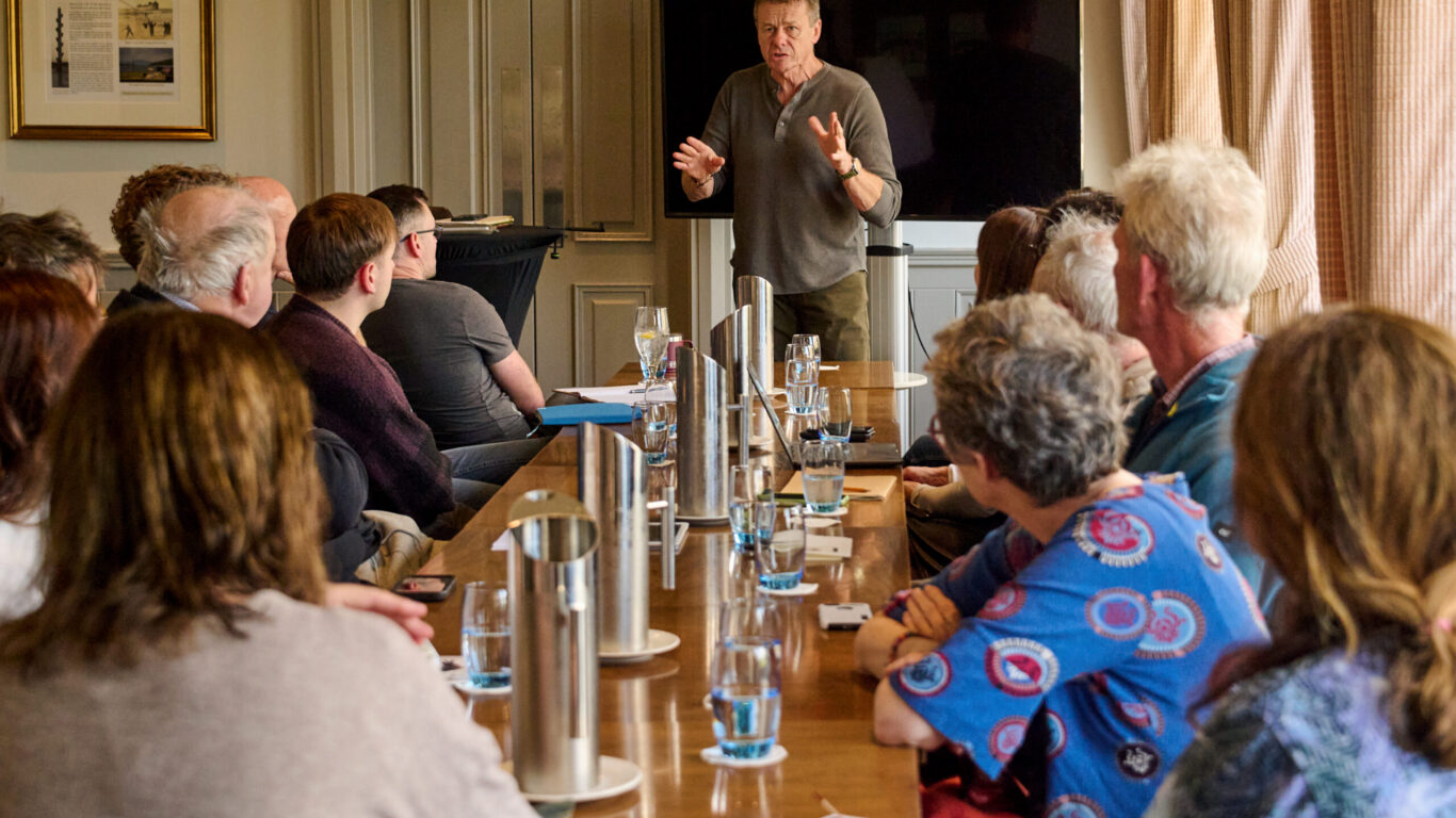 Guests enjoy an engaging presentation in a well-lit conference room, featuring comfortable seating and modern amenities.